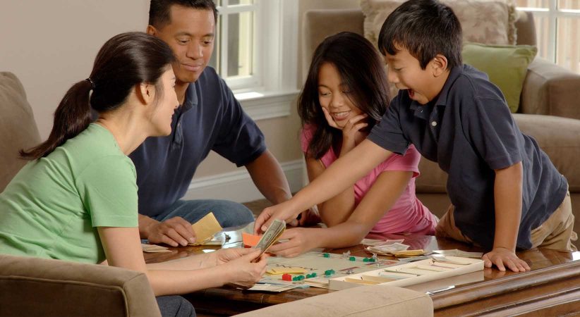 A family plays a board game at a table.