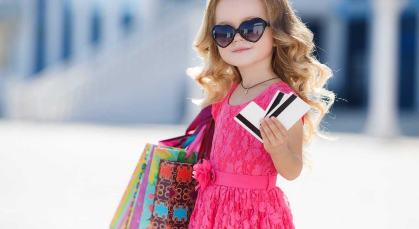Small girl holding shopping bags and credit cards