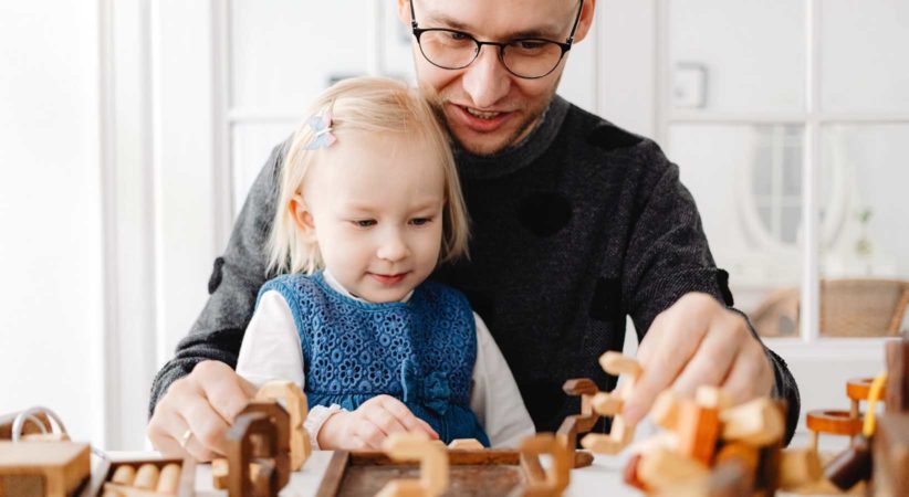 A man and toddler play with math toys