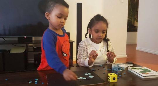 Two children play a game on a coffee table