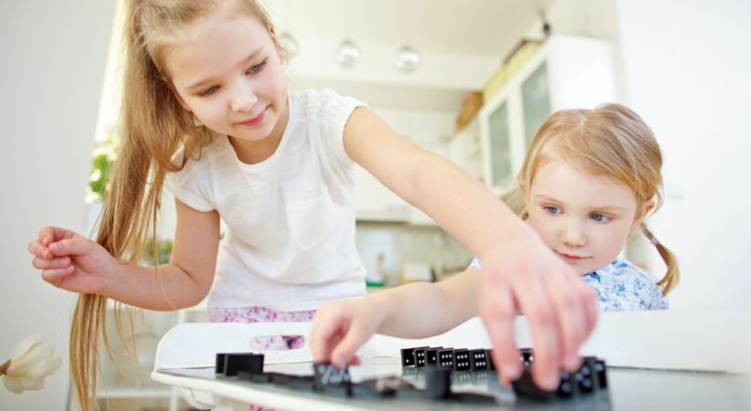 Two children playing with dominoes