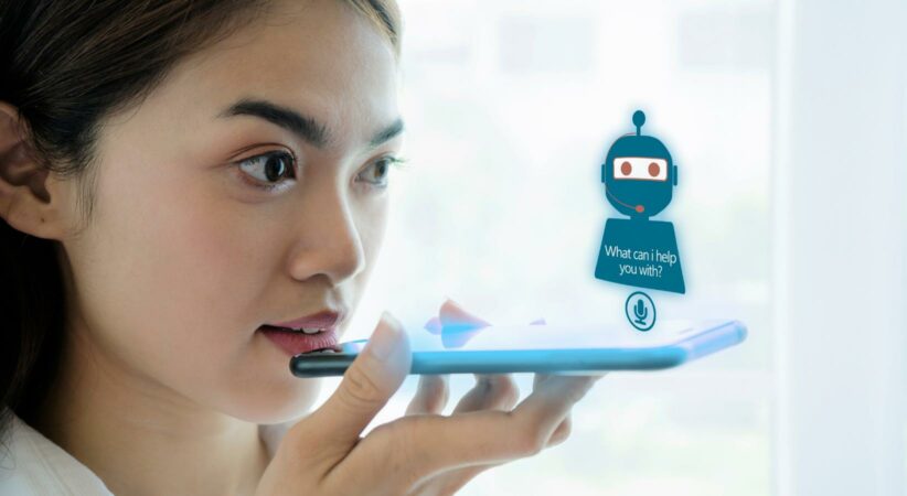 A woman speaks into a cellular phone to an Artificial Intelligence chat bot.