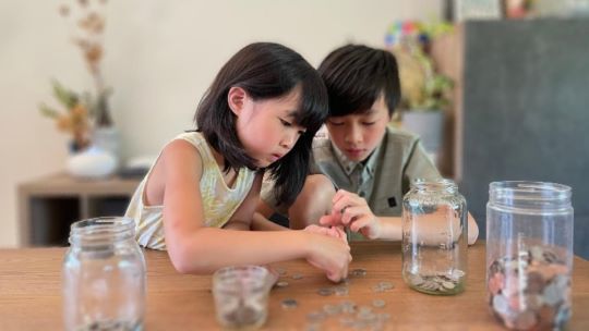 Two children are counting coins.
