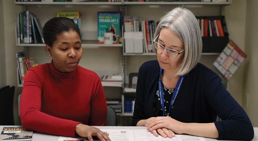 woman learning alongside a literacy practitioner